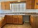 Functional kitchen showcasing wood cabinets and stainless steel double sink at 1805 San Luis Ln, The Villages, FL 32159