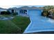 A tidy home features a freshly sodded lawn, a stamped concrete driveway, and an attached garage, all in a single-story design at 1805 San Luis Ln, The Villages, FL 32159