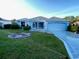 Charming one-story home with a manicured lawn and inviting front yard, plus a driveway leading to an attached garage at 1805 San Luis Ln, The Villages, FL 32159