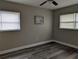 Bedroom with neutral walls, updated flooring, ceiling fan, and natural light from two windows at 2013 Sarazen Ct, Orlando, FL 32808