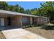 Inviting single-story home featuring a cozy porch, landscaping, and a convenient covered carport at 2013 Sarazen Ct, Orlando, FL 32808