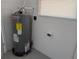 Small utility room with a Rheem water heater, a window with blinds, and white concrete walls at 2013 Sarazen Ct, Orlando, FL 32808