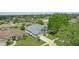This is an aerial view of a lovely blue house in a desirable neighborhood with mature trees and well-kept lawns at 212 Hazeltine Dr, Debary, FL 32713