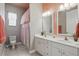 Bright bathroom features double sinks, a toilet and a shower with a decorative shower curtain at 212 Hazeltine Dr, Debary, FL 32713