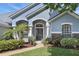 Inviting front entrance with decorative columns and manicured landscaping, complemented by a glass paneled door at 212 Hazeltine Dr, Debary, FL 32713