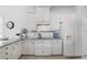 Clean and efficient kitchen with white cabinets, dark hardware, and tile floors, offering a modern design at 212 Hazeltine Dr, Debary, FL 32713