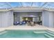 A screened lanai includes an outdoor kitchen, dining area, and lounge seating, next to the pool at 212 Hazeltine Dr, Debary, FL 32713