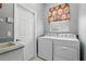 Functional laundry room with modern washer and dryer units, cabinet, and a sink at 212 Hazeltine Dr, Debary, FL 32713