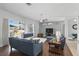 Spacious living area featuring hardwood floors, blue sofas, and sliding glass doors to the lanai at 212 Hazeltine Dr, Debary, FL 32713