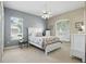 Bright main bedroom featuring a ceiling fan, white furniture, and beach-themed decor creating a relaxing atmosphere at 212 Hazeltine Dr, Debary, FL 32713