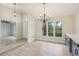 Dining room featuring a modern chandelier, light wood flooring, and wine bar with a drink refrigerator at 216 Shady Oaks Cir, Lake Mary, FL 32746