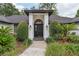 Inviting front entrance featuring a black door, white brick pillars, and professionally landscaped yard at 216 Shady Oaks Cir, Lake Mary, FL 32746
