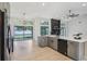 Well-lit kitchen featuring an island, gray cabinets, and stainless steel appliances, flowing to other rooms at 216 Shady Oaks Cir, Lake Mary, FL 32746