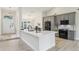 Stylish kitchen featuring a large island, gray cabinetry, stainless steel appliances, and elegant lighting fixtures at 216 Shady Oaks Cir, Lake Mary, FL 32746