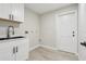 The laundry room features sleek white cabinets, black hardware, and wood-look flooring at 216 Shady Oaks Cir, Lake Mary, FL 32746