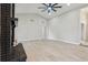 Bright and spacious living room with wood-look tile flooring, a modern ceiling fan, and a black brick fireplace at 216 Shady Oaks Cir, Lake Mary, FL 32746