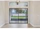 Bright view through sliding glass doors to screened patio, backyard, and white privacy fence at 216 Shady Oaks Cir, Lake Mary, FL 32746