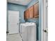 Functional laundry room with washer, dryer, and overhead storage cabinets at 2167 Velvet Leaf Dr, Ocoee, FL 34761