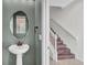 Powder room featuring pedestal sink, oval mirror, and vintage bronze hardware at 2167 Velvet Leaf Dr, Ocoee, FL 34761
