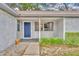 Inviting front porch featuring a blue door, gray siding, and greenery around the entryway at 217 E Hillcrest St, Altamonte Springs, FL 32701