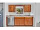A well-lit kitchen featuring wood cabinets, granite countertops, stainless steel appliances, and a window at 217 E Hillcrest St, Altamonte Springs, FL 32701