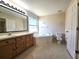 En-suite bathroom with dual sink vanity, soaking tub, and natural light from a frosted window at 224 Lake Charles Dr, Davenport, FL 33837