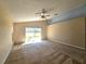 Primary bedroom featuring carpet flooring, vaulted ceiling, and sliding glass doors leading to the backyard at 224 Lake Charles Dr, Davenport, FL 33837