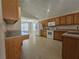Spacious kitchen with wooden cabinetry, white appliances, and an adjoining dining area at 224 Lake Charles Dr, Davenport, FL 33837