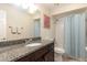 Bathroom featuring granite-style countertop, spacious mirror, and tub with shower and light-blue shower curtain at 2259 King Johns Ct, Winter Park, FL 32792