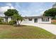 Charming single-story home with a well-manicured lawn, a palm tree and a welcoming blue front door at 2259 King Johns Ct, Winter Park, FL 32792