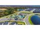 Aerial shot of the community pool, nearby ponds, and neatly arranged rows of residential houses, showcasing the neighborhood layout at 2400 Reading Trl, Kissimmee, FL 34746