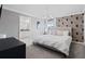 Neutral bedroom boasting a patterned accent wall, modern light fixture, and en-suite bathroom at 2400 Reading Trl, Kissimmee, FL 34746