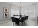 Elegant dining room with modern chandelier, window with white curtains, and seating for eight at 2400 Reading Trl, Kissimmee, FL 34746