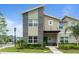 Charming two-story home with a mix of stone and stucco exterior, front yard, and a covered porch at 2400 Reading Trl, Kissimmee, FL 34746