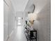 Bright hallway with tiled floors, console table with lamp, and decorative wallpaper at 2400 Reading Trl, Kissimmee, FL 34746