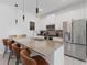 Modern kitchen featuring stainless steel appliances, a large island with bar stool seating, and pendant lighting at 2400 Reading Trl, Kissimmee, FL 34746
