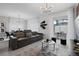 Bright, open-concept living room featuring a large leather sofa, modern lighting fixture, and dining area with backyard pool views at 2400 Reading Trl, Kissimmee, FL 34746