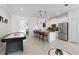 Open living space with a modern kitchen, dining area, air hockey table, and tile flooring throughout at 2400 Reading Trl, Kissimmee, FL 34746