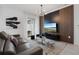 Modern living room featuring a comfortable leather sofa, stylish entertainment center, and sliding glass doors at 2400 Reading Trl, Kissimmee, FL 34746