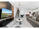 Open-concept living room with a large TV, staircase, pool table, and a modern kitchen with a breakfast bar at 2400 Reading Trl, Kissimmee, FL 34746