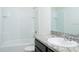 Bathroom featuring granite vanity, tiled shower-tub combo, and white tile accents at 2607 Tulip Dr, Davenport, FL 33837