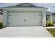 This home features a spacious two-car garage with carriage accents and a concrete driveway at 2607 Tulip Dr, Davenport, FL 33837