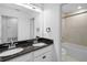 Bright bathroom featuring a double vanity with black granite counters and a separate tub/shower combo at 2730 Parkfield Rd, St Cloud, FL 34772