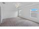 Bedroom features neutral carpet, two windows, and modern lighting fixture at 2730 Parkfield Rd, St Cloud, FL 34772