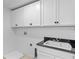 Laundry room equipped with sleek white cabinets, sink, and modern countertops at 2730 Parkfield Rd, St Cloud, FL 34772