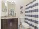 Well-lit bathroom with a vanity, granite countertop, and a shower-tub combination at 309 Verona Ave, Davenport, FL 33897
