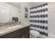 Bathroom with granite countertop vanity, decorative art, and a striped shower curtain at 309 Verona Ave, Davenport, FL 33897
