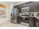 Modern kitchen with dark cabinets, stainless steel appliances, and granite countertops at 309 Verona Ave, Davenport, FL 33897