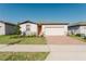 Charming single-story home featuring a brick driveway, two-car garage, and well-manicured lawn at 349 Guadlupe St, Haines City, FL 33844