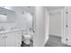 Hallway view to a remodeled bathroom with white cabinets, gray floors, and modern fixtures at 358 Prevo Dr, Apopka, FL 32712